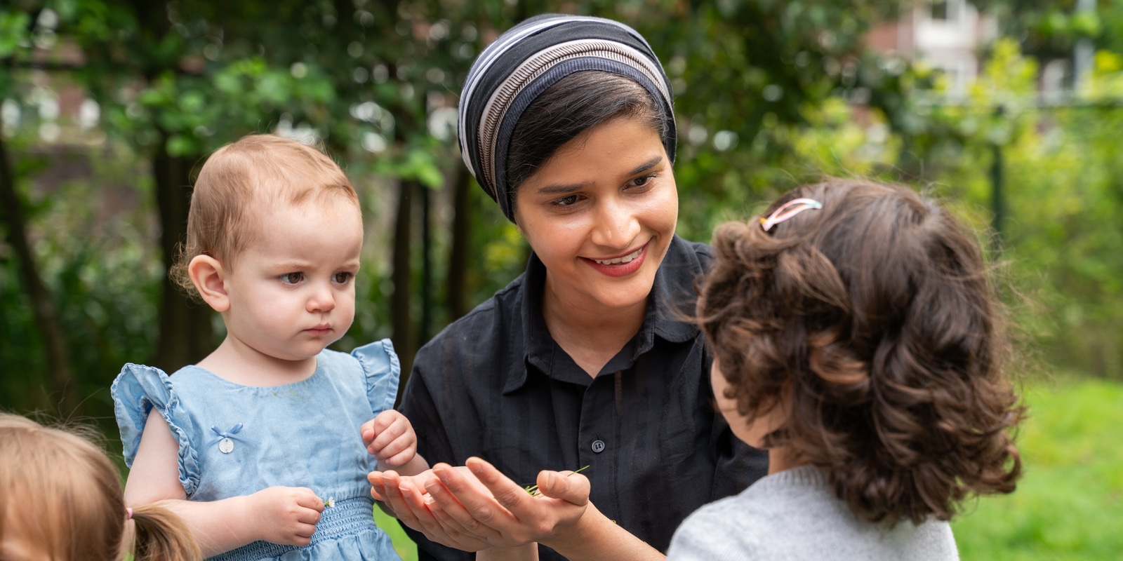 Childcare teacher smiles to children