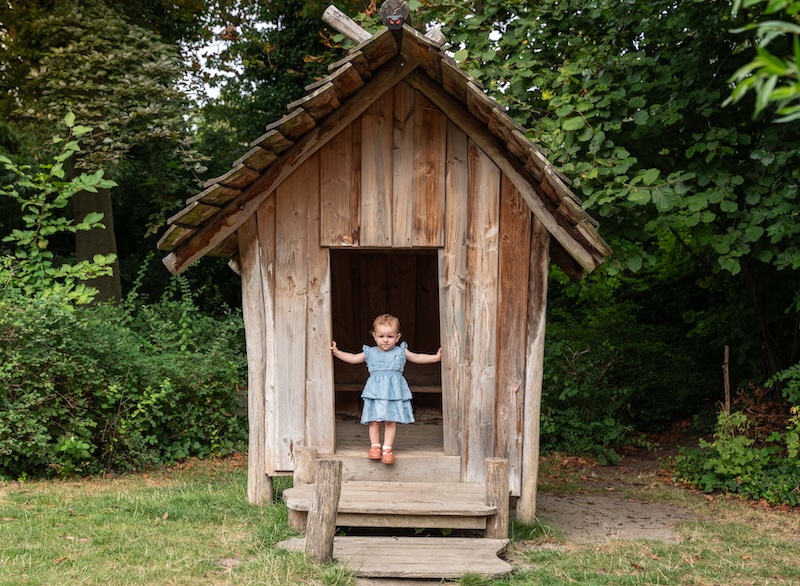 Girl standing in wooden house at Basker International Childcare
