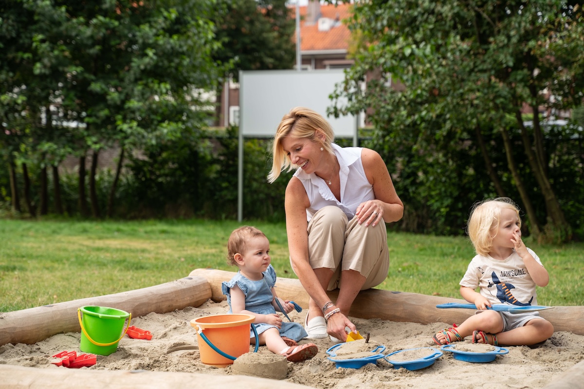 Children and teacher are playing with sand