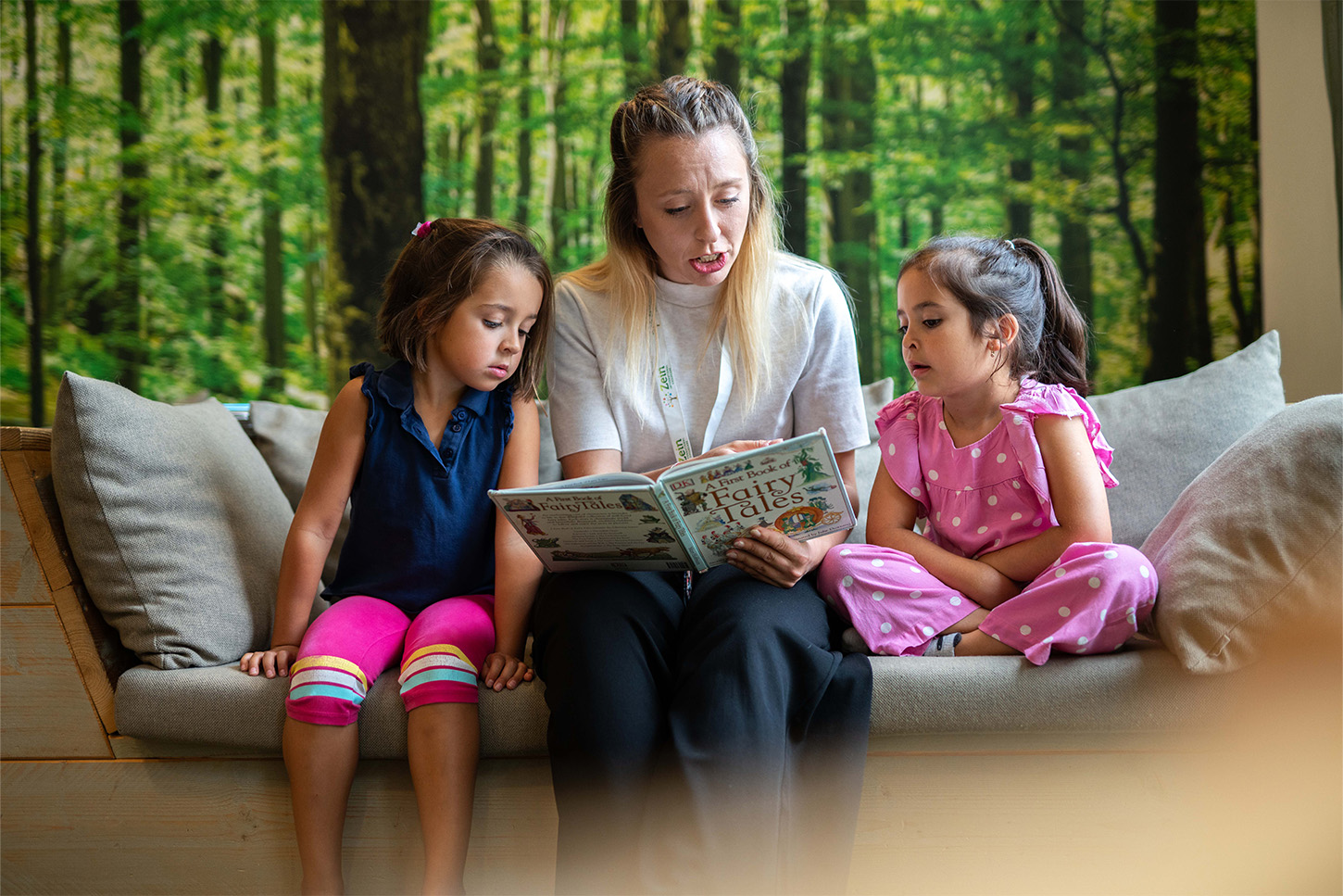 Teacher with girls reading an English book