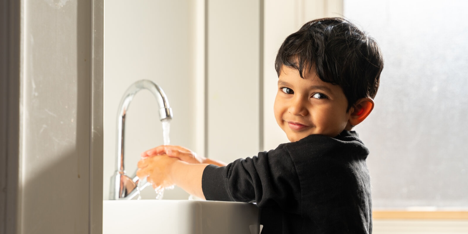 Child at Basker Childcare washes hands