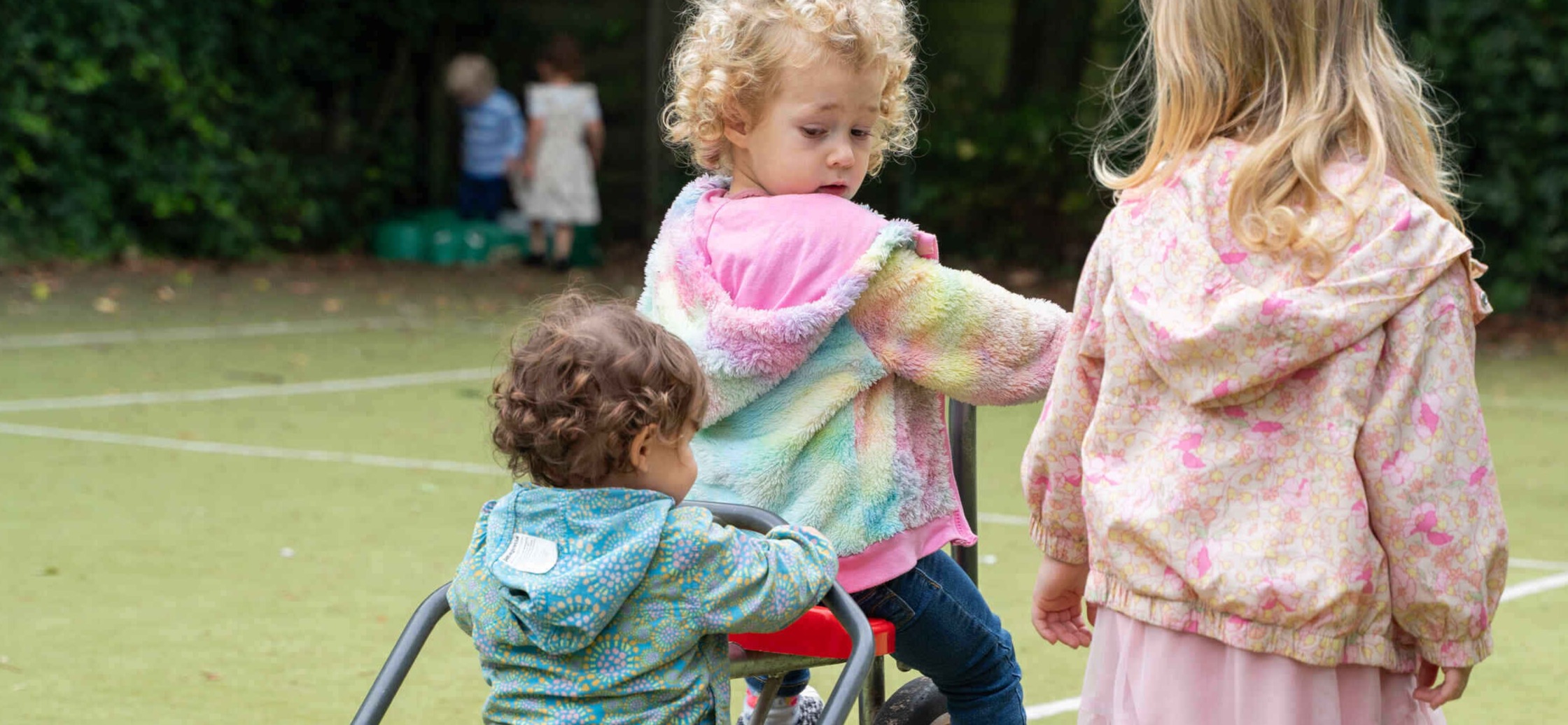 Children share bike at Basker International Childcare