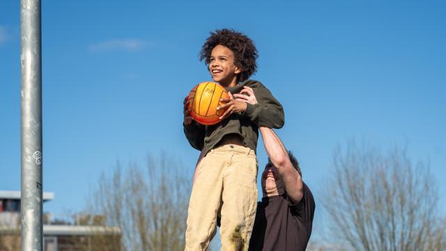 Child plays with ball outside
