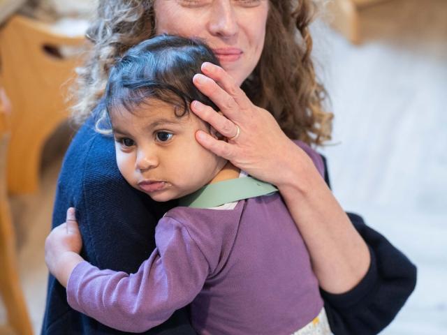 Basker International Childcare teacher cuddles baby