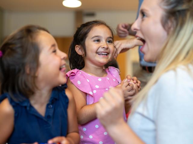 Children laughing with after school care teacher at Basker