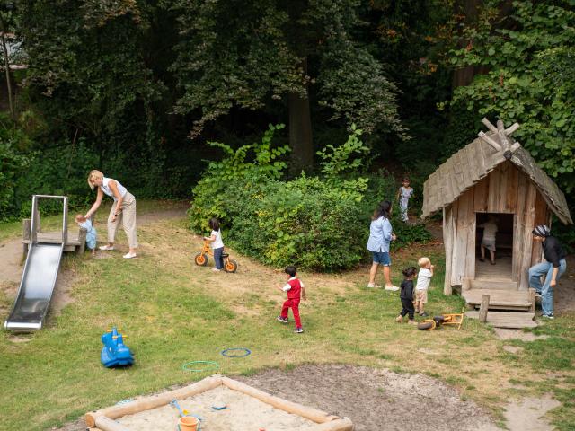 Overview of the playground with playhouse, sandbox and slide