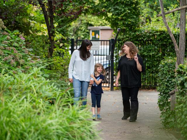 Parent and Childcare Teacher Walking with a Child 