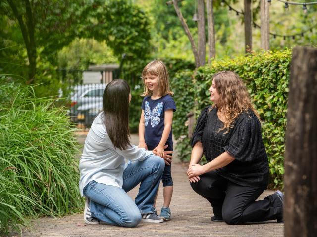 Mother daughter and teacher saying goodbye