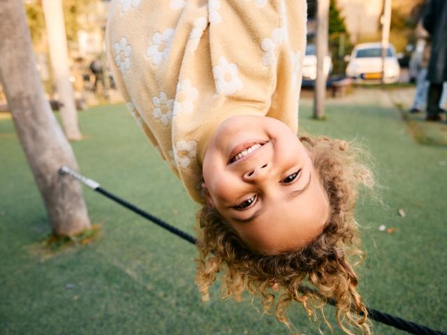 Girl hanging upside down at Basker International Childcare
