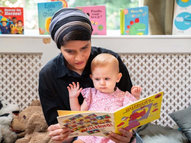 Pedagogic professional and little girl reading a book