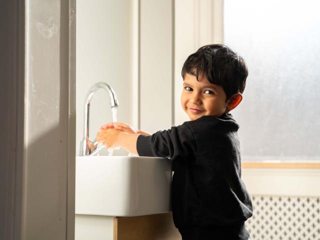 Boy washing hands at Basker International Childcare
