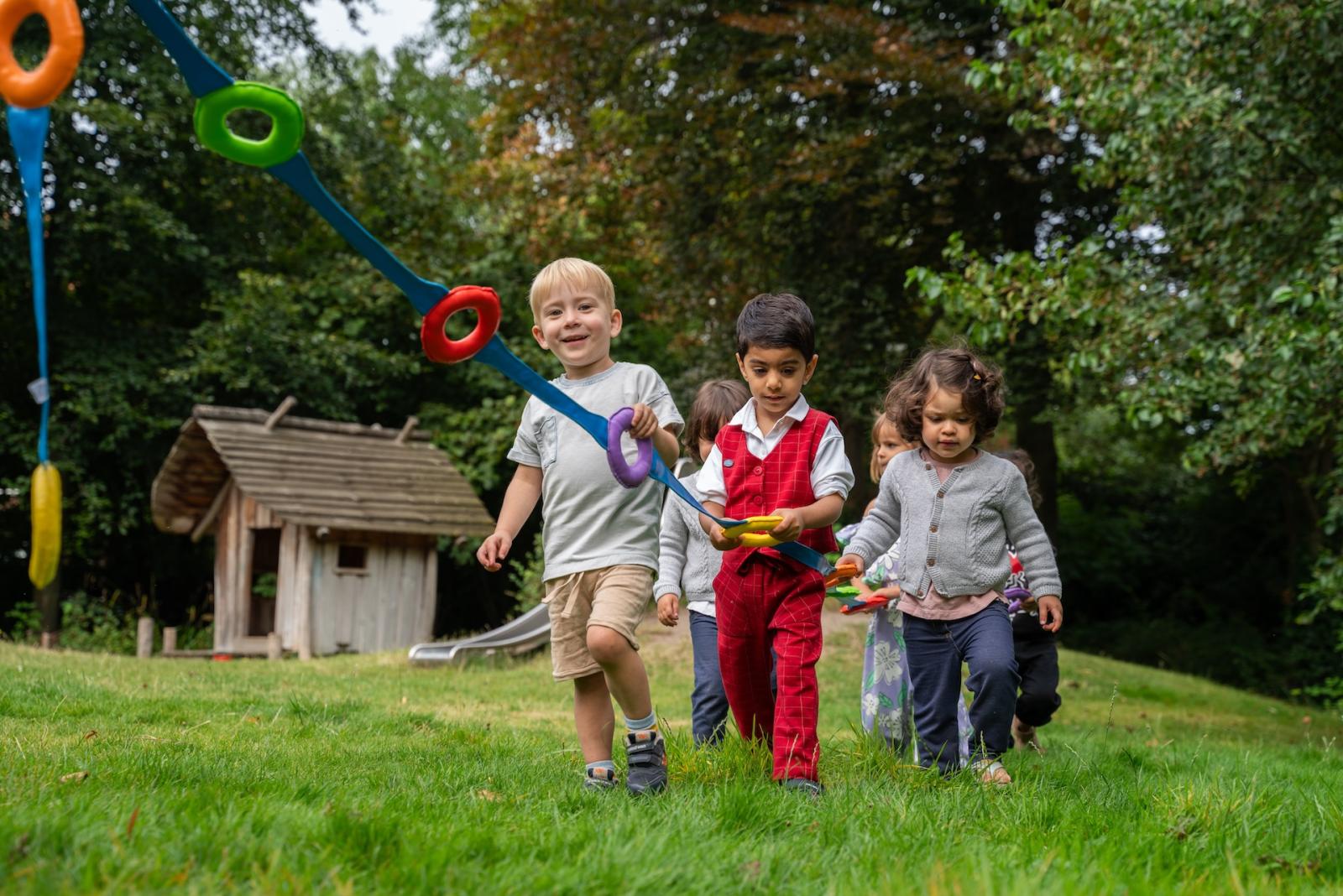 Children walking together in garden at Basker childcare