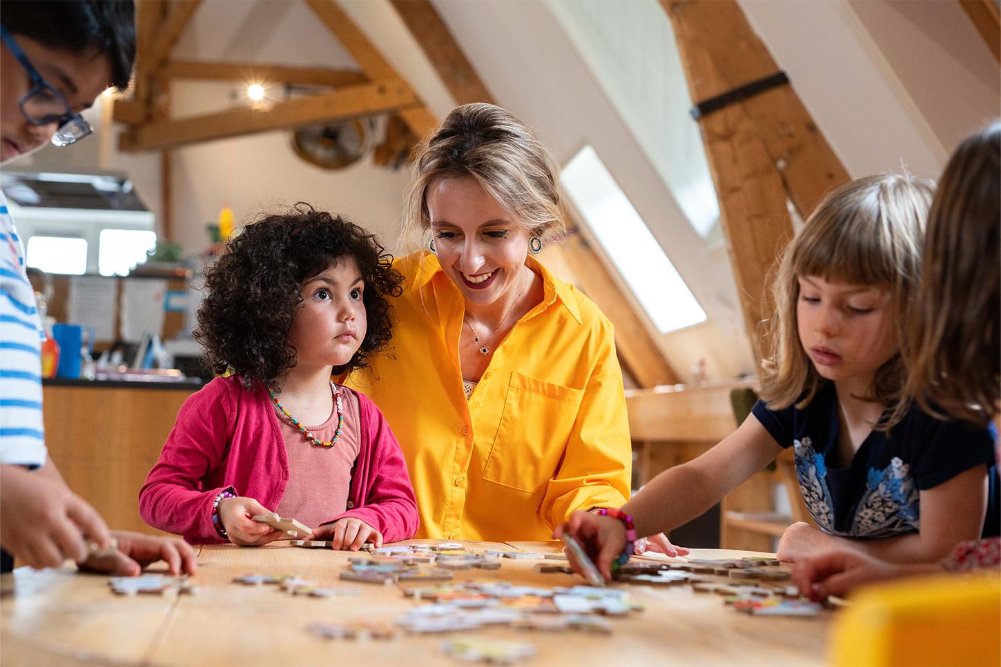 Children making a puzzle with pedagogical professional at Basker International