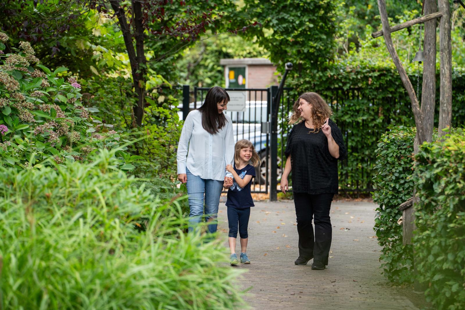 Parent and Childcare Teacher Walking with a Child 