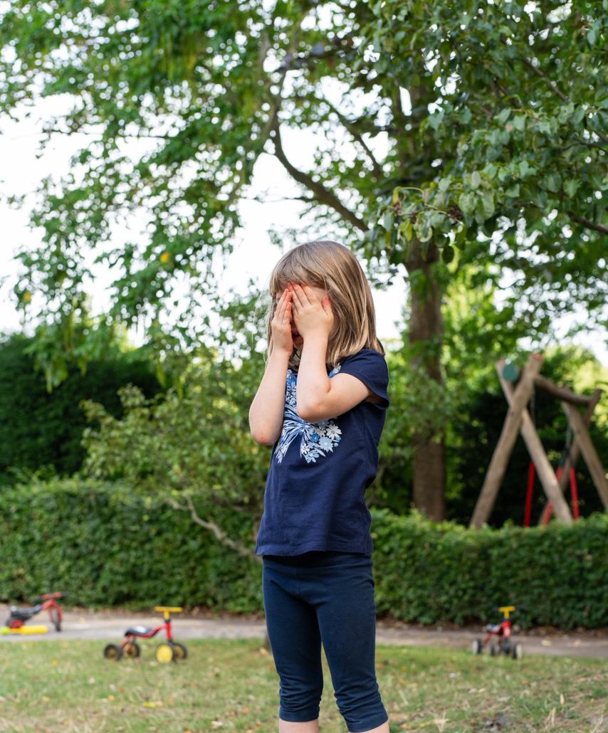 Girl at Holiday Camps hiding her face with her hands