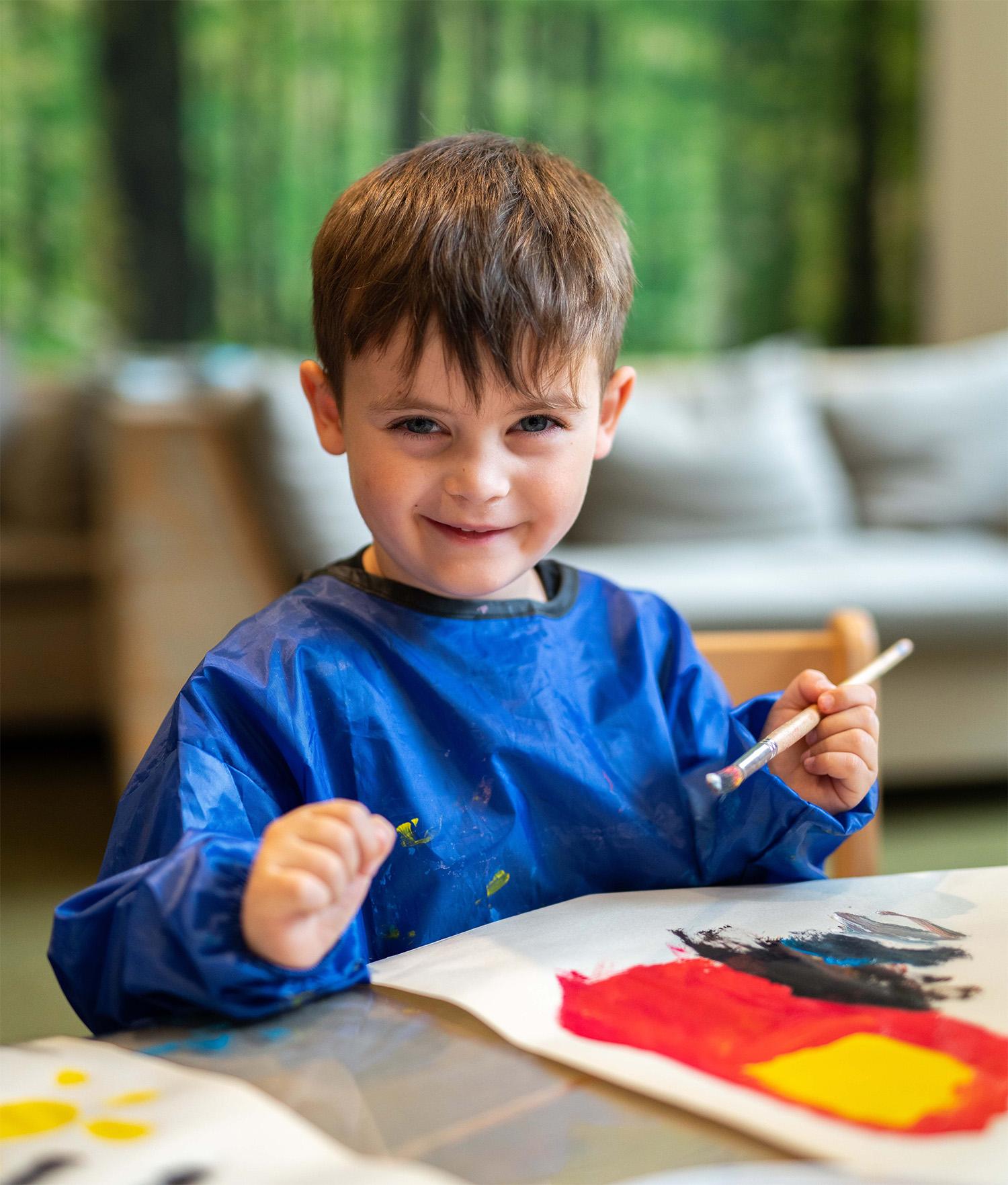 Basker International Childcare header boy with paint