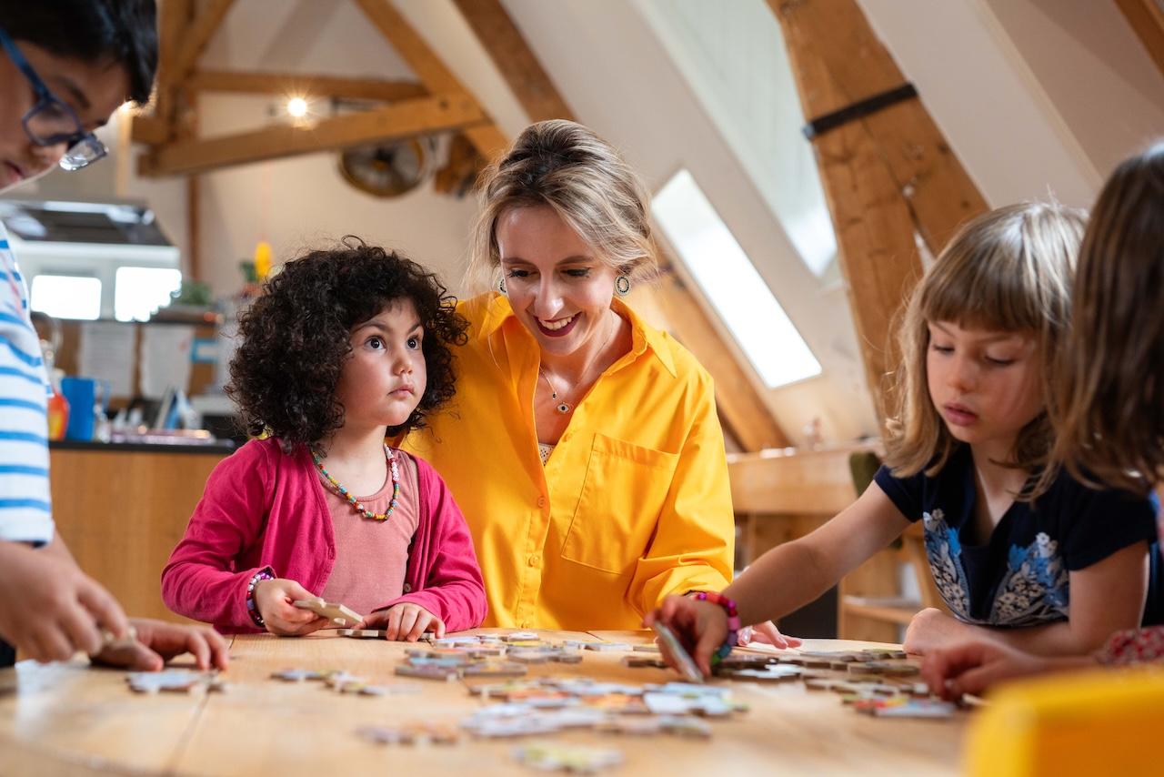 Children and teacher making a puzzle