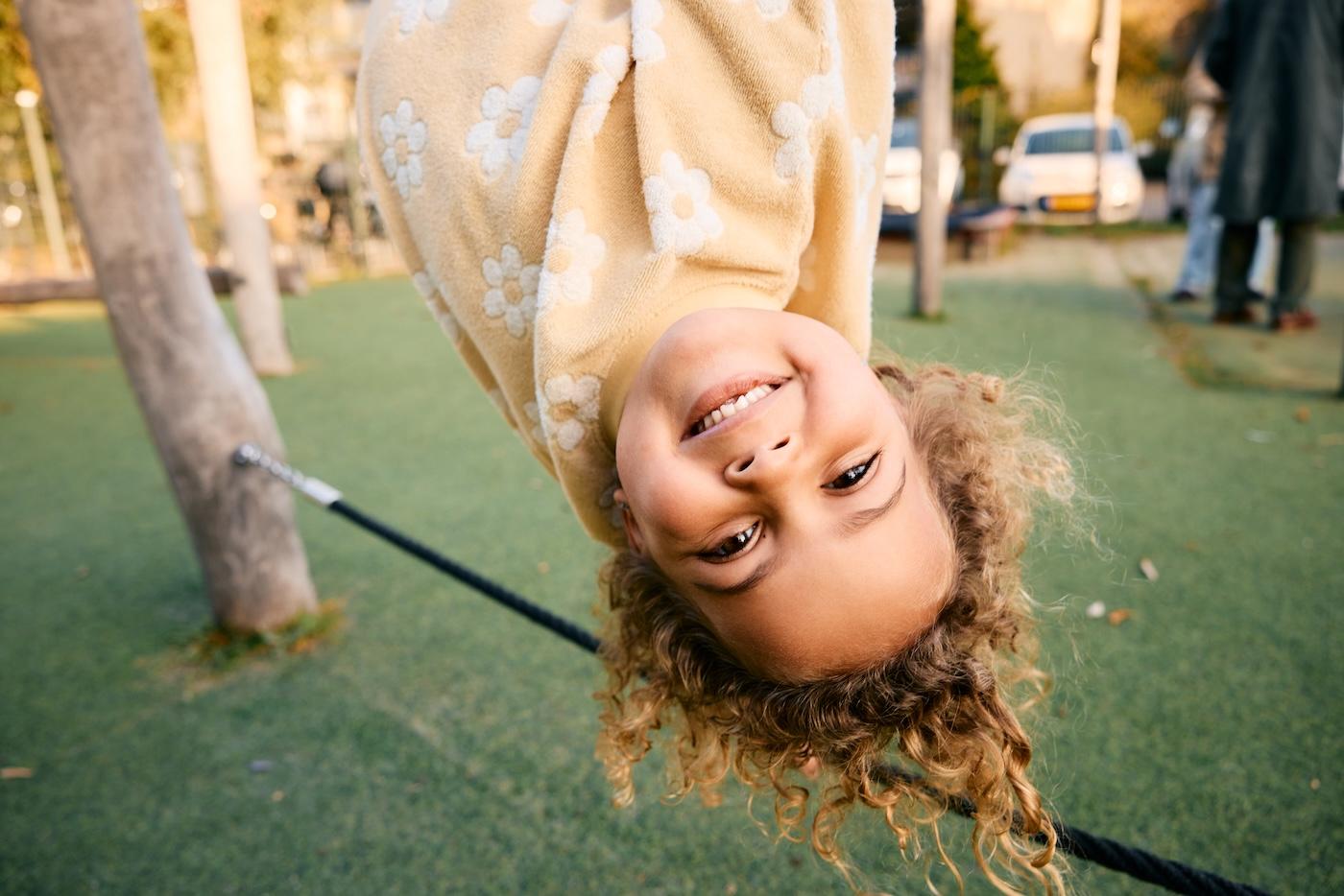 Girl hanging upside down at Basker International Childcare